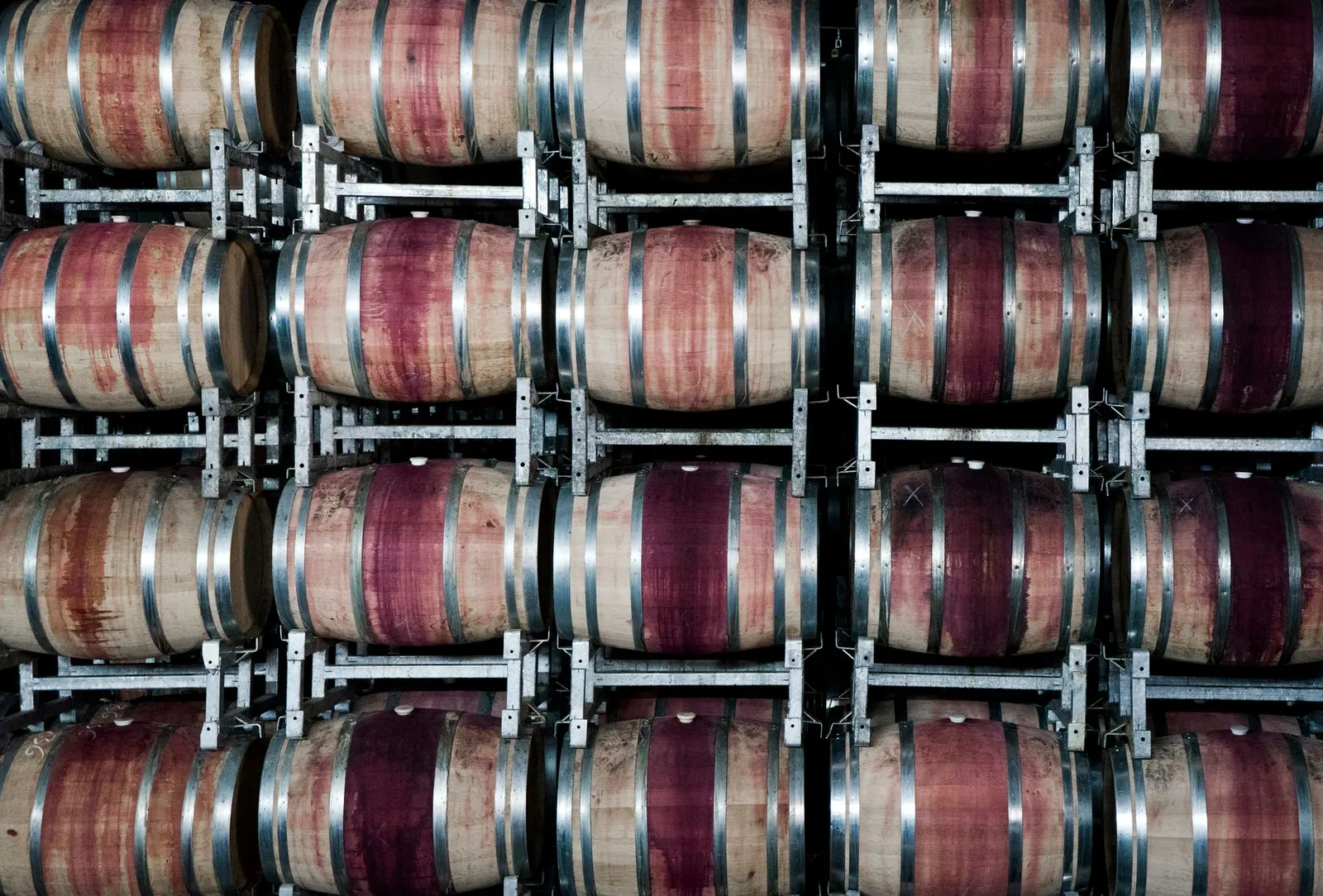 Stacked wooden barrels in a winery storing wine, highlighting the art of winemaking